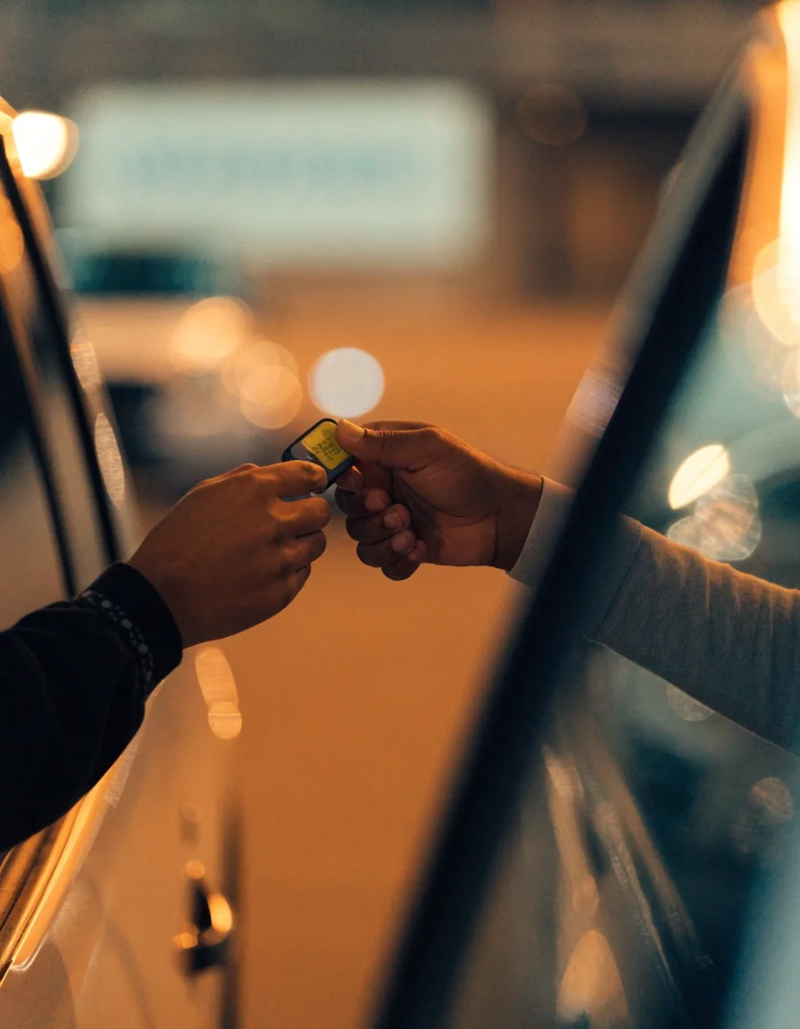 Hands exchanging a car key at valet drop-off
